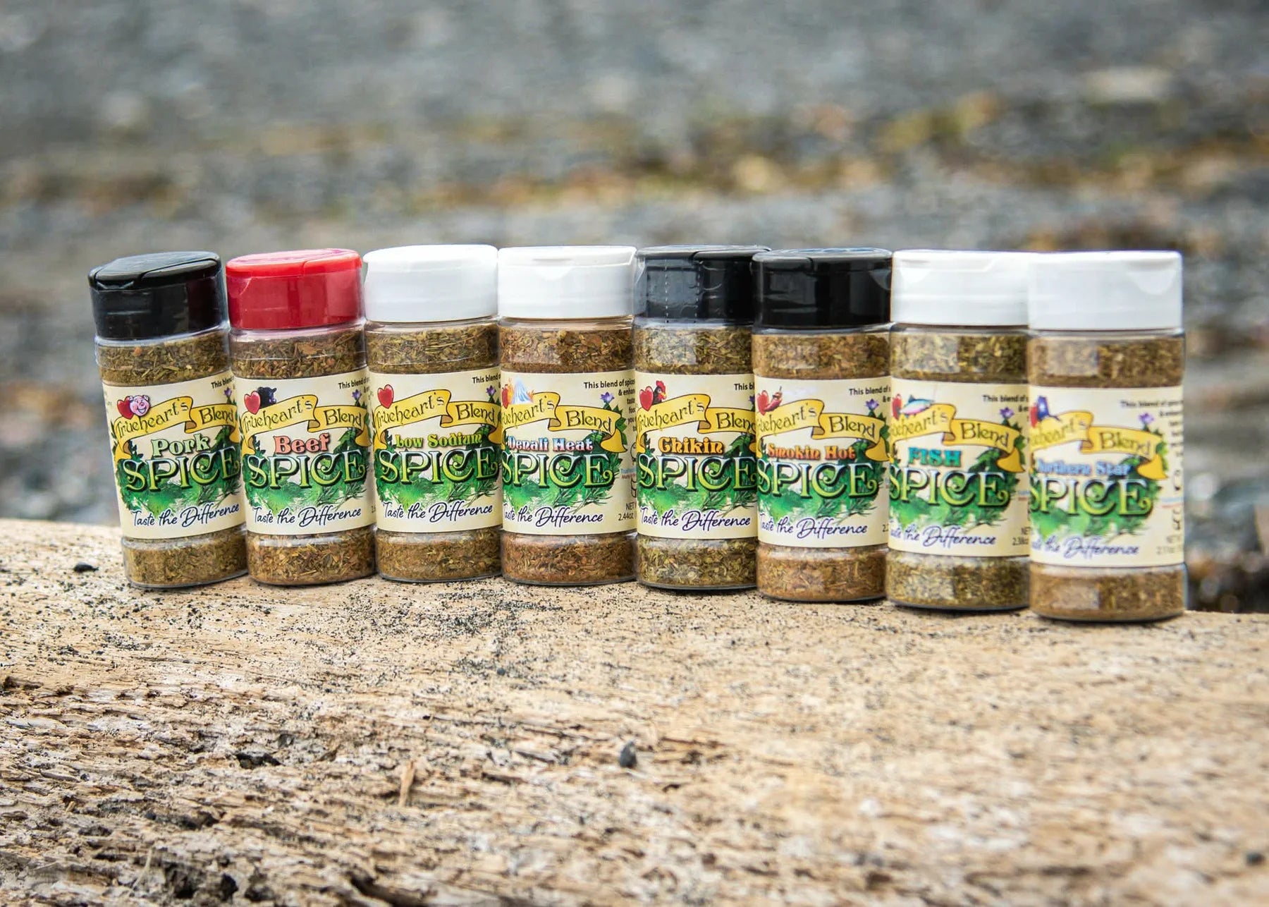 The original eight Trueheart's Blend seasoning jars lined up on weathered wood